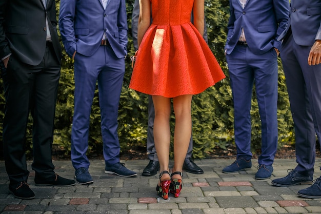 Free photo five mans in suits and one female in orange dress over green wall from leafs.