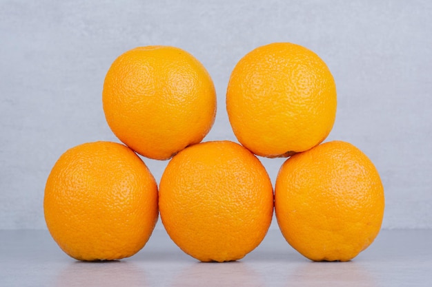 白い背景の上の5つの全体のおいしいオレンジ。高品質の写真