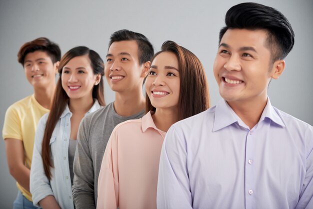 Five young people standing in row looking sideways