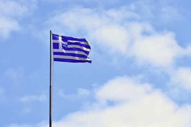 바람과 푸른 하늘에서 비행하는 그리스의 국기. 여행 및 휴가 여름 배경입니다. 그리스 크레타