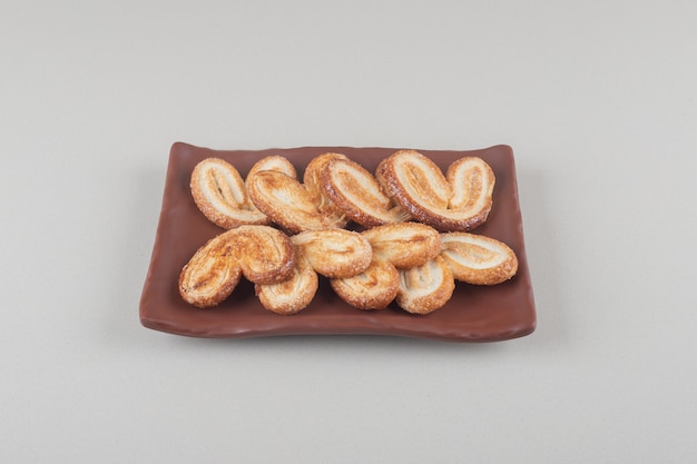 Flaky cookies bundle on a platter on white background.