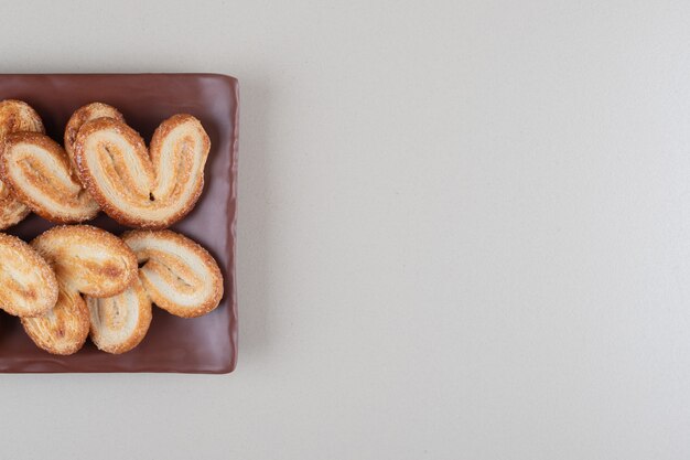 Flaky cookies bundle on a platter on white background.