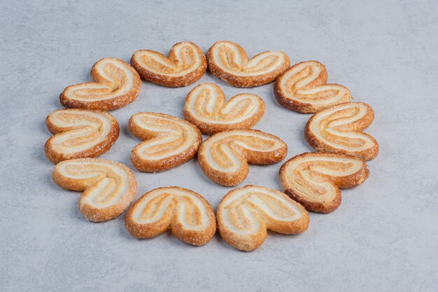 Flaky cookies bundled together on marble surface