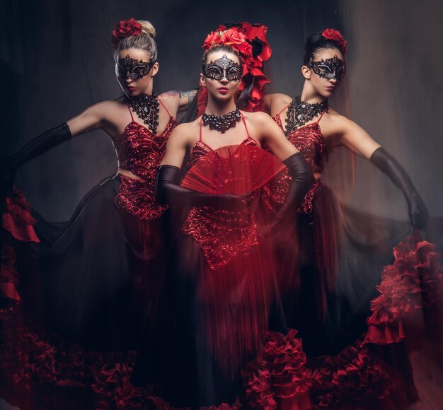Испанские соблазнительные танцоры фламенко в традиционных костюмах. Изолированные на темном фоне.