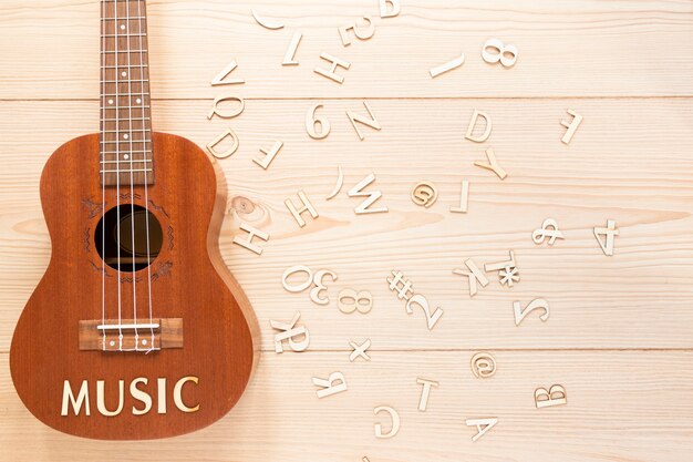 Flat lay acoustic guitar with wooden letters