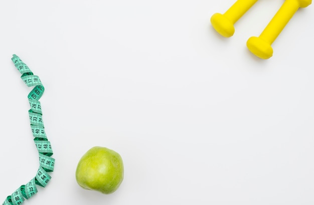 Free photo flat lay of apple with measuring tape and weights