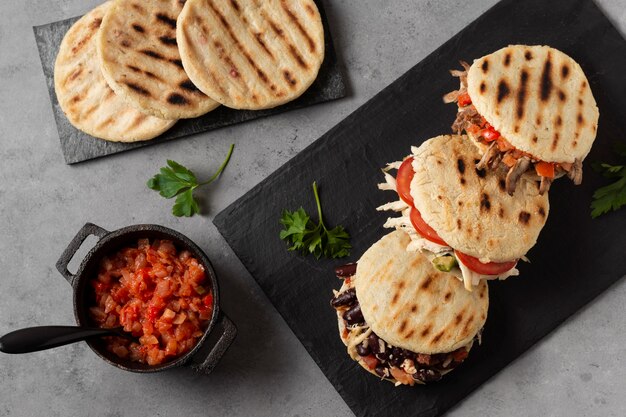 Flat lay arepas with meat and tomatoes