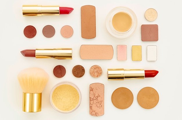 Free photo flat lay arrangement of colorful cosmetics on white background