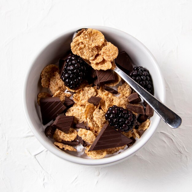 Flat lay arrangement of healthy bowl cereals with chocolate