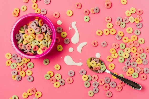 Flat lay arrangement with cereal bowl and pink background