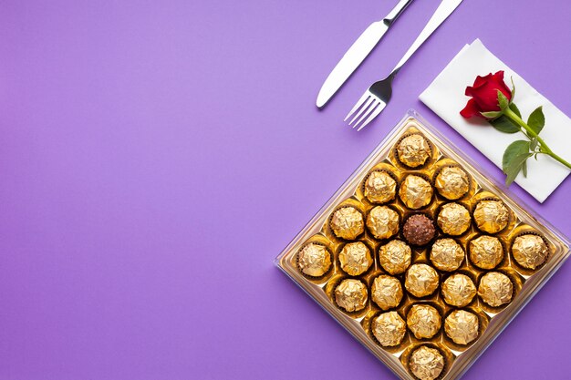 Flat lay arrangement with chocolate box and rose