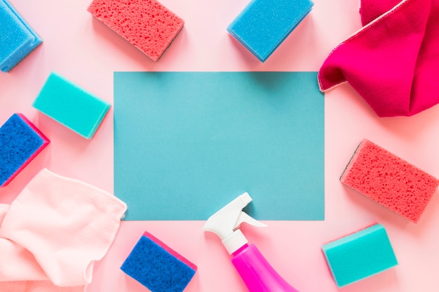 Flat lay arrangement with cleaning products on pink background