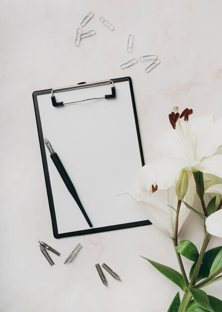 Flat lay arrangement with clipboard and pen