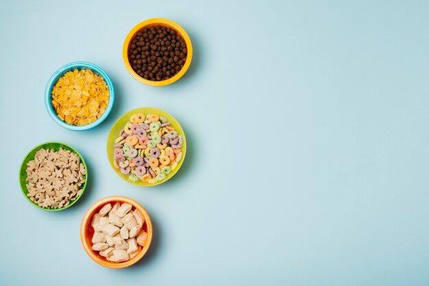 Flat lay arrangement with colorful bowl and cereals 