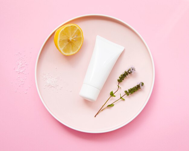 Flat lay arrangement with cream bottle and half lemon