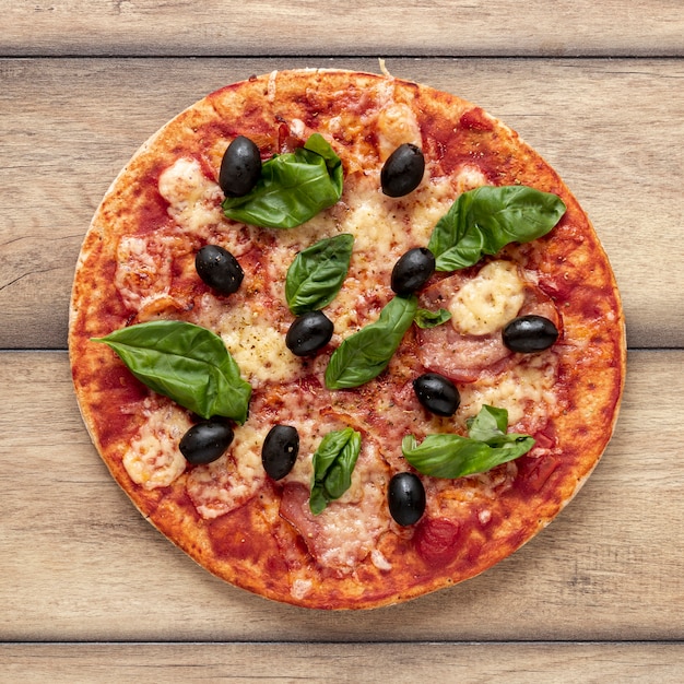 Flat lay arrangement with delicious pizza and wooden background