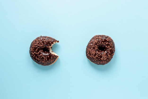 Flat lay arrangement with doughnuts and blue background