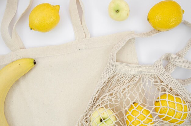 Плоская планировка с фруктами и хлопковой сумкой