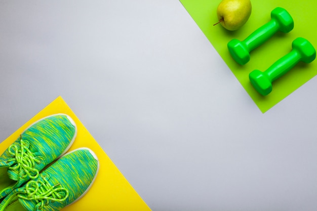 Flat lay arrangement with green shoes and dumbbells