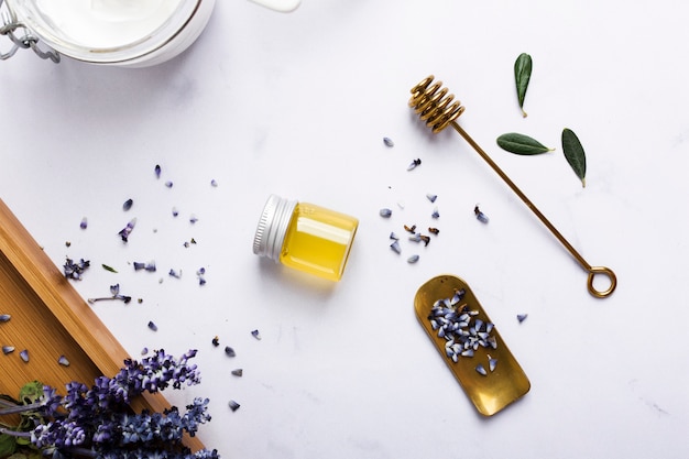 Flat lay arrangement with honey bottle and flower