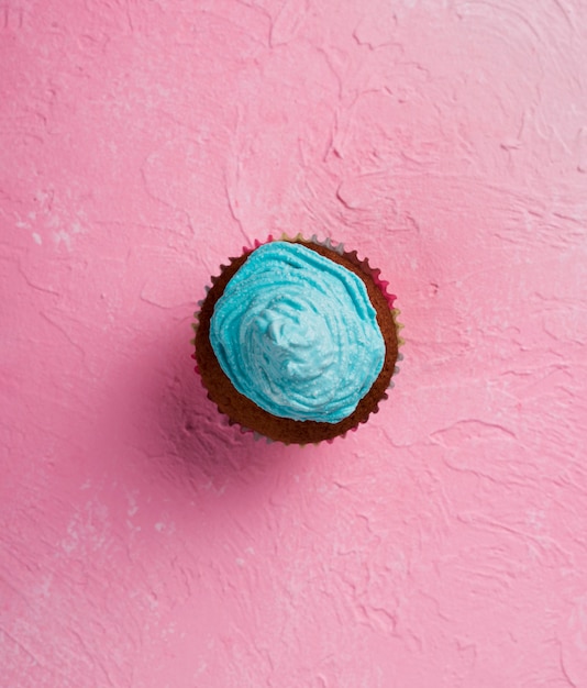 Foto gratuita disposizione piana laica con muffin su sfondo rosa