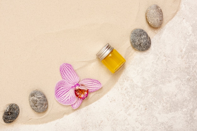 Flat lay arrangement with oil, stones and flower