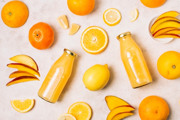 Flat lay arrangement with orange fruits and smoothies