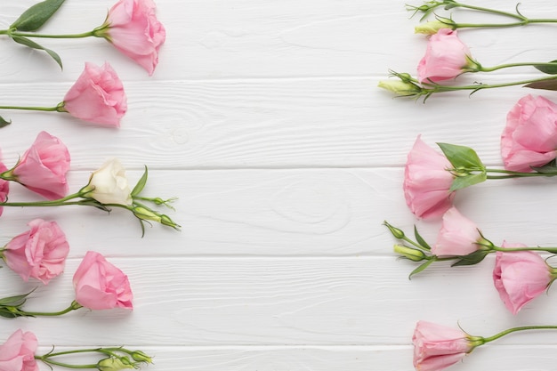 Flat lay arrangement with pink roses on wooden background