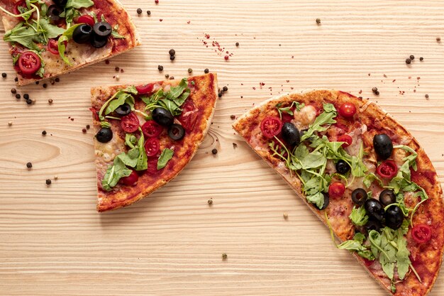 Flat lay arrangement with pizza and wooden background