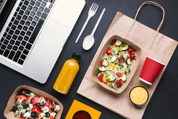 Flat lay arrangement with salad and laptop