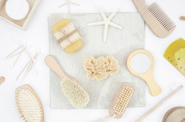 Flat lay arrangement with wooden brushes and mirror