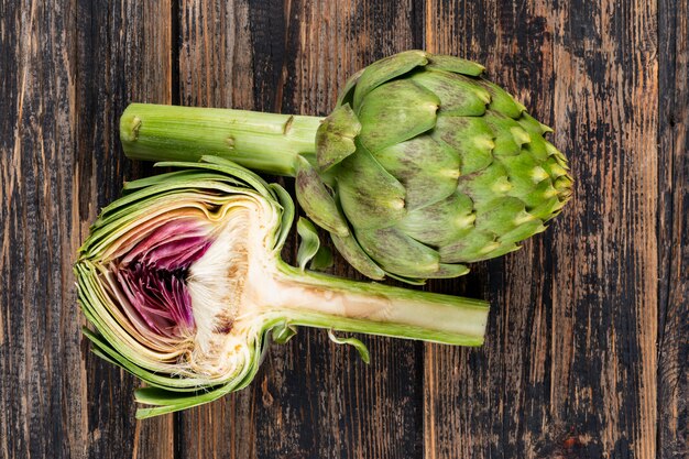 Flat lay artichoke and a slice on dark wooden background. horizontal
