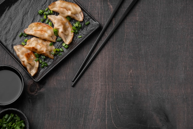 Flat lay of asian dumplings dish on slate with copy space