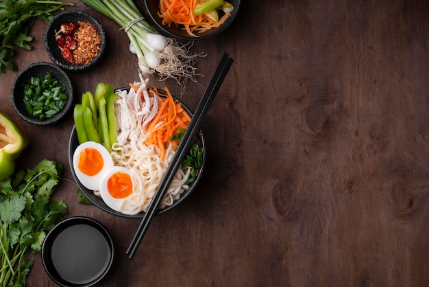 Flat lay of asian noodles with eggs and copy space