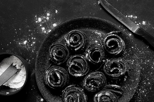 Flat lay assortment of black delicious food in dark plate