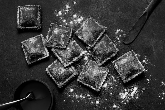 Flat lay assortment of black delicious food on dark table