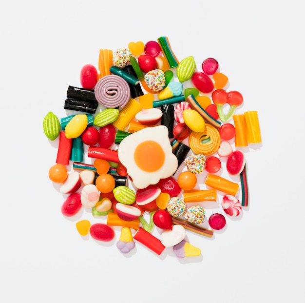 Flat lay assortment of colorful candies on white background