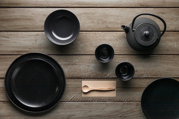 Flat lay of assortment of dinnerware with teapot and wooden spoon