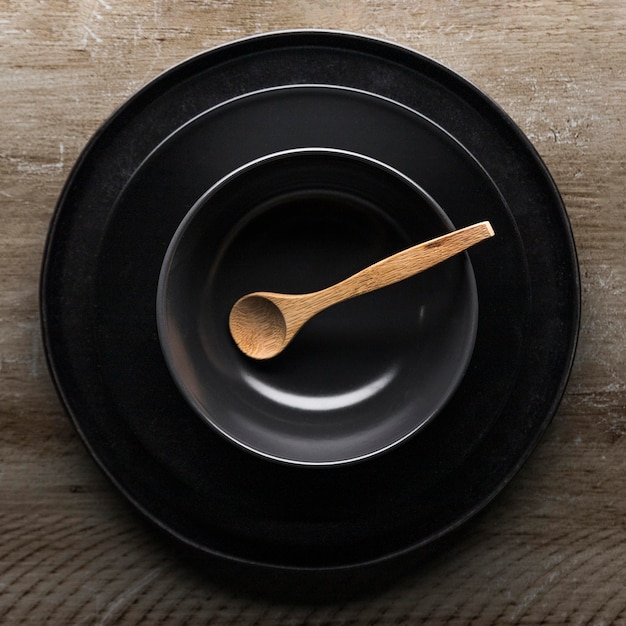 Flat lay of assortment of dinnerware with wooden spoon