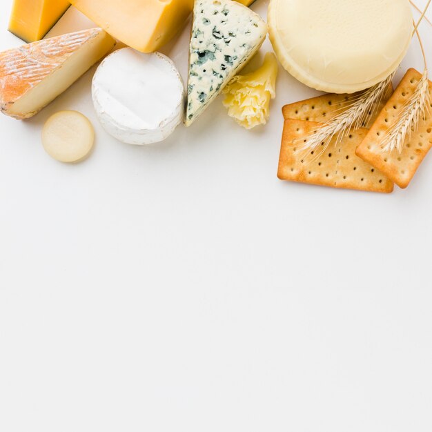Flat lay assortment of gourmet cheese and crackers with copy space
