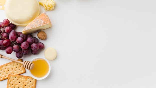 Flat lay assortment of gourmet cheese and grapes with copy space