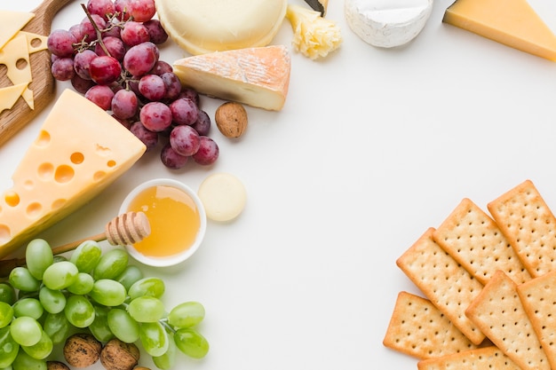 Flat lay assortment of gourmet cheese and grapes with crackers