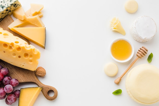 Flat lay assortment of gourmet cheese and honey with copy space