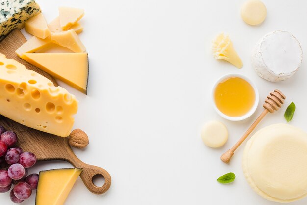 Flat lay assortment of gourmet cheese and honey with copy space