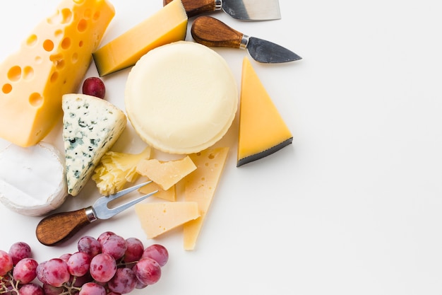 Flat lay assortment of gourmet cheese with cheese knives