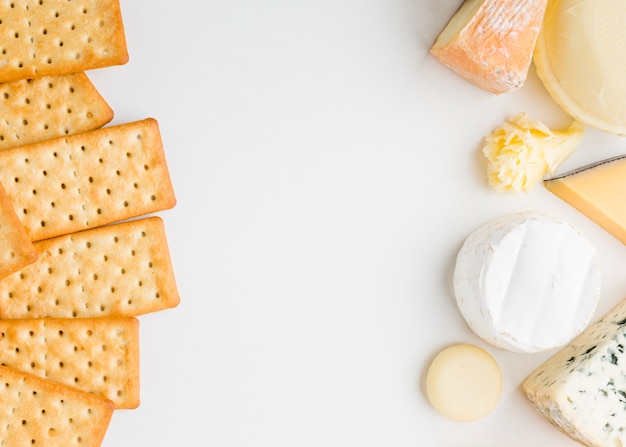 Flat lay assortment of gourmet cheese with crackers