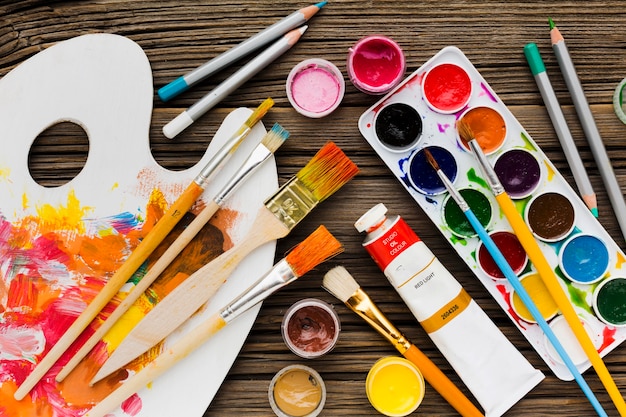 Flat lay assortment of paint brushes and pencils