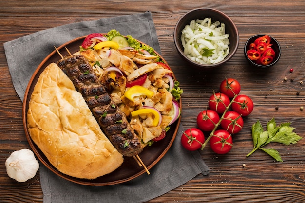 Flat lay of assortment of tasty kebab with tomatoes and herbs