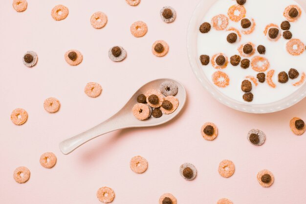 Flat lay assortment with colorful cereals and milk bowl