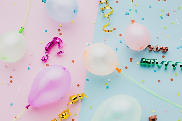 Flat lay assortment with colourful confetti and balloons